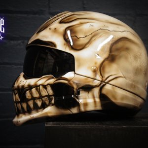 Bone-colored motorcycle helmet with photorealistic human skull airbrush design featuring anatomical details and crack effects